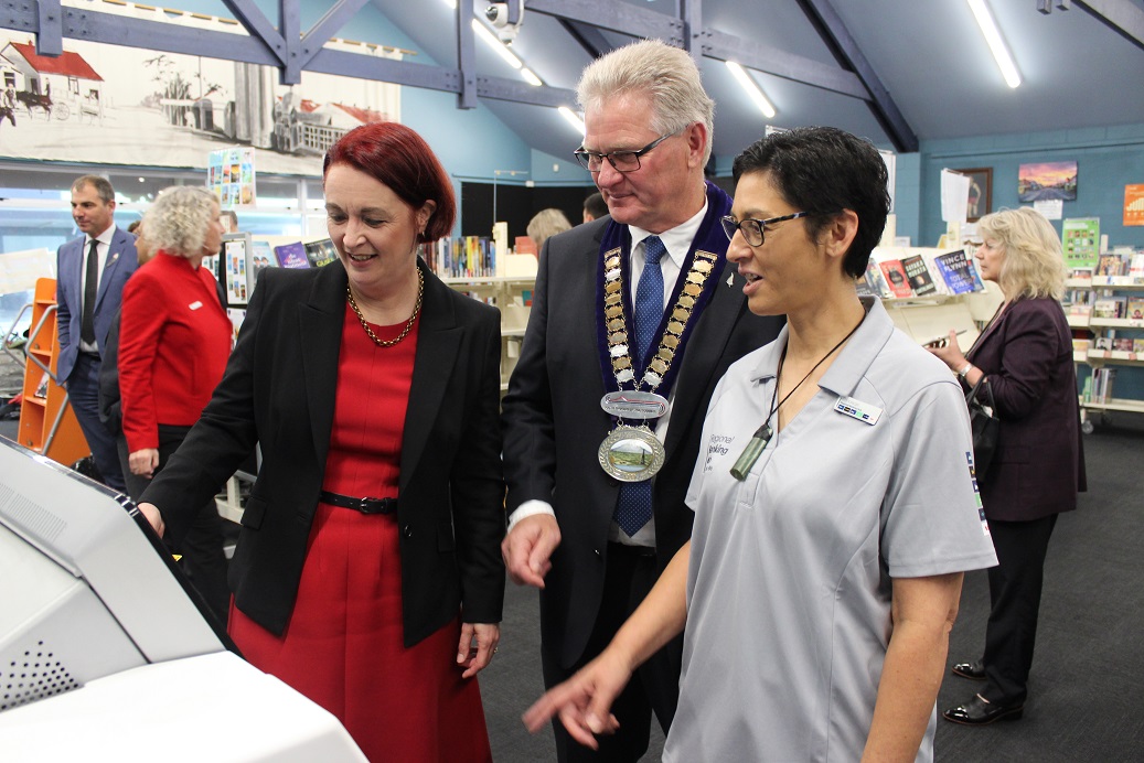 Dr Deborah Russell, parliamentary undersecretary for revenue, South Taranaki Mayor, Phil Nixon and banking concierge Quisandra Webby try out the new Smart ATM at the opening of the Ōpunakē​ Banking Hub
