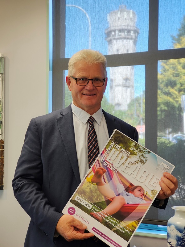 South Taranaki Mayor Phil Nixon holding a copy of the 2021- 2031 Long Term Plan