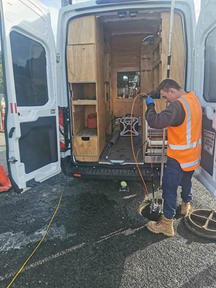 contractor putting cctv camera down a manhole